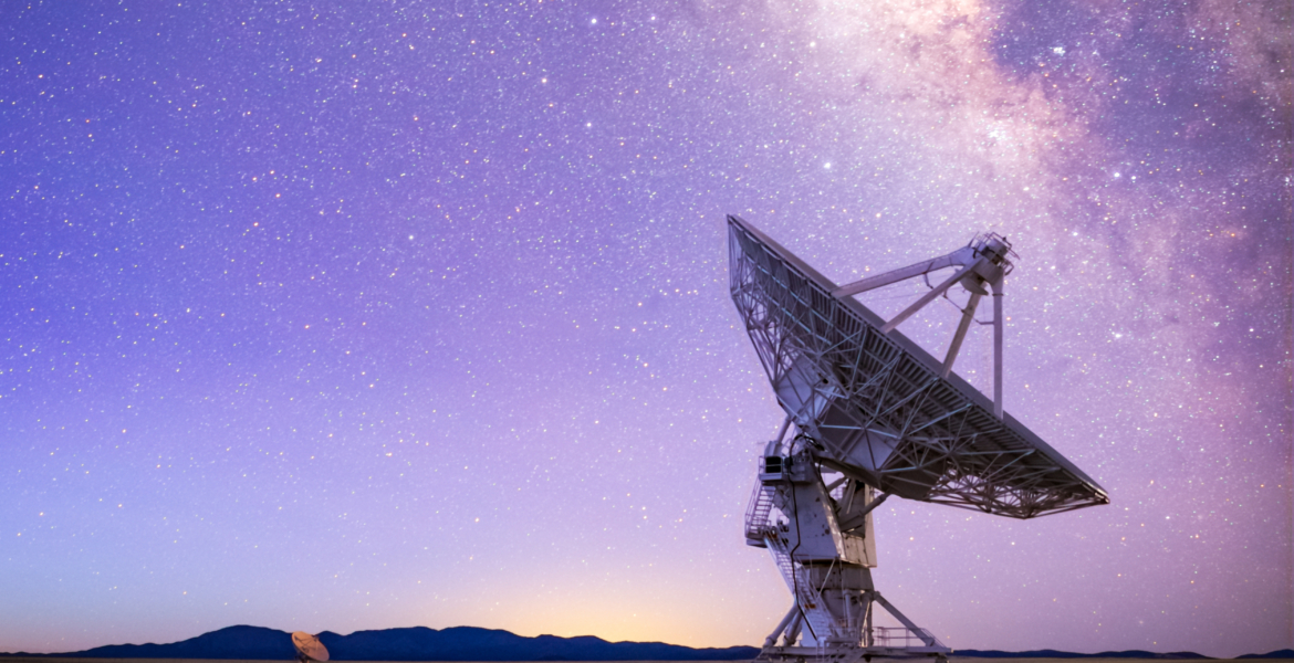 A Very Large Array antenna beneath the Milky Way at night